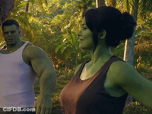 A Man And A Woman Are Standing Next To Each Other In The Jungle GIF