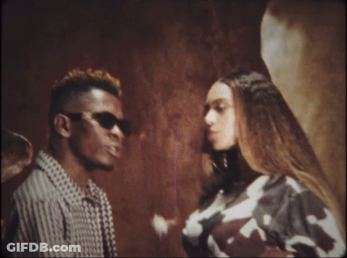 A Man And A Woman Are Standing Next To Each Other Looking At Each Other GIF