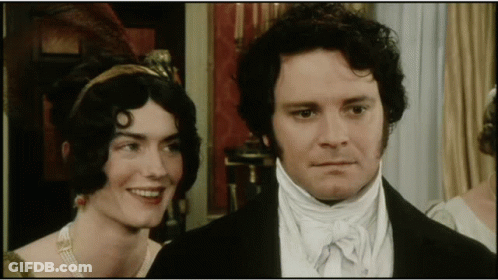 A Man And A Woman Are Standing Next To Each Other GIF