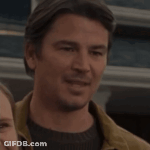 A Man And A Woman Are Standing Next To Each Other GIF