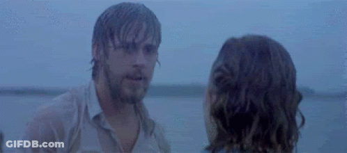 A Man And A Woman Are Standing Next To Each Other On A Beach Looking At Each Other . GIF