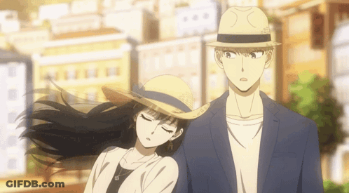 A Man And A Woman Are Standing Next To Each Other On A City Street . GIF