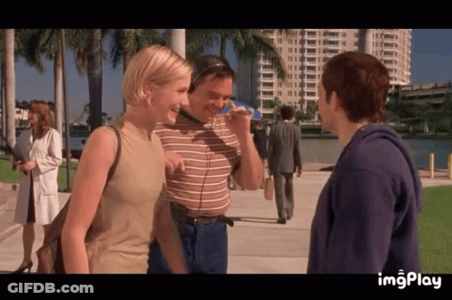 A Man And A Woman Are Standing Next To Each Other On A Sidewalk With The Word Imgplay At The Bottom Of The Screen GIF