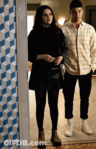 A Man And A Woman Are Standing Next To Each Other On A Tiled Floor GIF