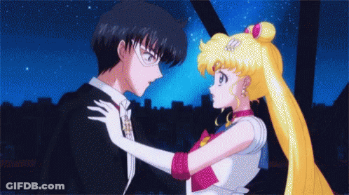 A Man And A Woman Are Standing Next To Each Other GIF