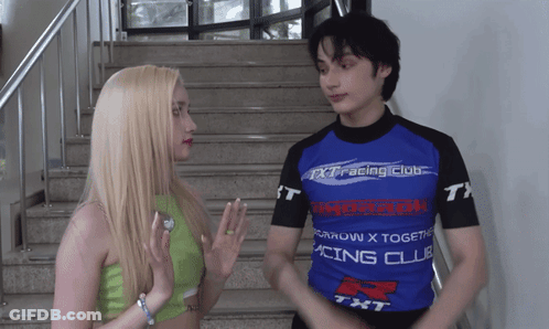 A Man And A Woman Are Standing Next To Each Other Wearing Shirts That Say Racing Club GIF