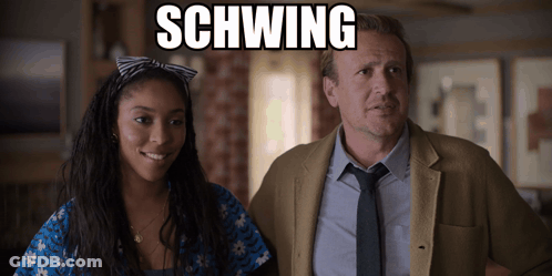 A Man And A Woman Are Standing Next To Each Other With Schwing Written On The Screen GIF