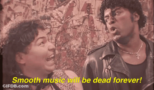 A Man And A Woman Are Standing Next To Each Other With Smooth Music Will Be Dead Forever Written In Yellow GIF