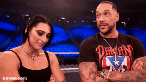 A Man And A Woman Are Standing Next To Each Other With The Man Wearing A Shirt That Says Dawn GIF