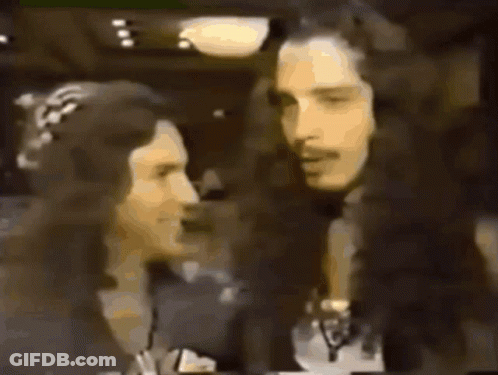 A Man And A Woman Are Standing Next To Each Other With The Name Chris Cornell On The Bottom Right GIF