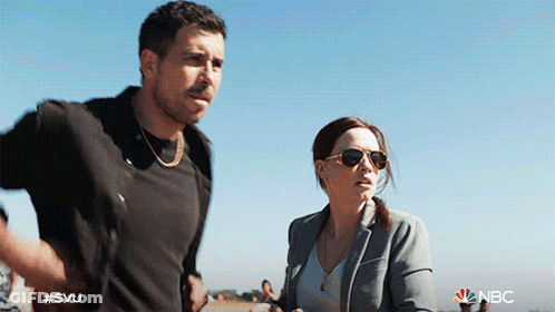 A Man And A Woman Are Standing Next To Each Other With The Nbc Logo Visible GIF