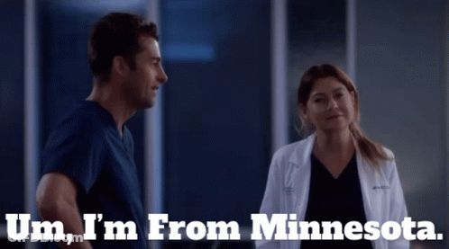 A Man And A Woman Are Standing Next To Each Other With The Words Um I 'M From Minnesota Behind Them GIF