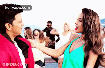 A Man And A Woman Are Standing Next To Each Other . GIF