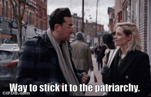 A Man And A Woman Are Standing On A Sidewalk With The Words Way To Stick It To The Patriarchy GIF