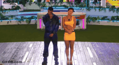 A Man And A Woman Are Standing On A Stage GIF