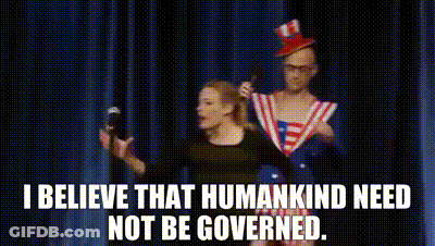 A Man And A Woman Are Standing On A Stage With A Microphone In Their Hands . GIF