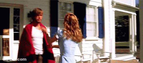 A Man And A Woman Are Standing Outside Of A White House . GIF