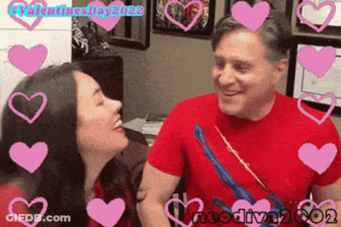 A Man And A Woman Are Surrounded By Pink Hearts With Valentines Day 2022 Written On The Bottom GIF