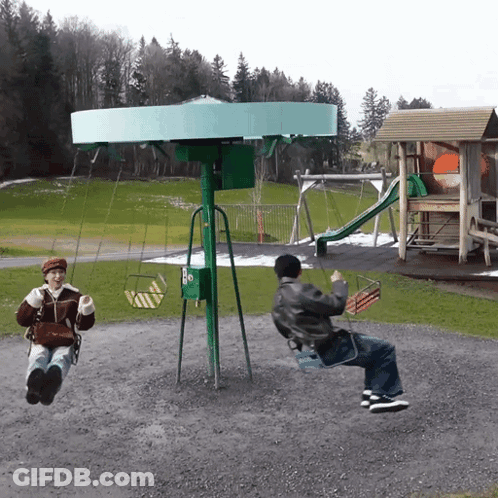 A Man And A Woman Are Swinging On A Green Swing Set GIF