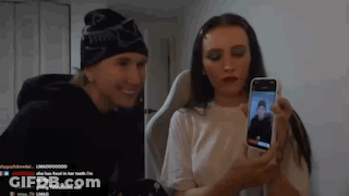 A Man And A Woman Are Taking A Picture Of Each Other With A Cell Phone . GIF