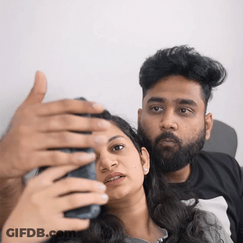 A Man And A Woman Are Taking A Selfie With Their Cell Phone GIF