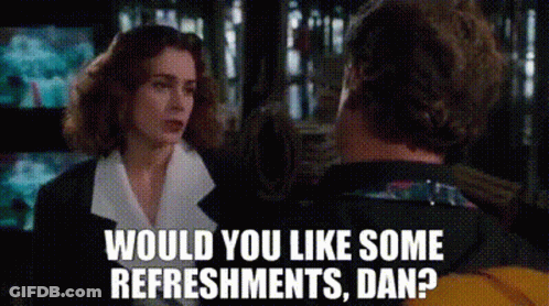 A Man And A Woman Are Talking To Each Other And The Woman Is Asking The Man If He Would Like Some Refreshments . GIF