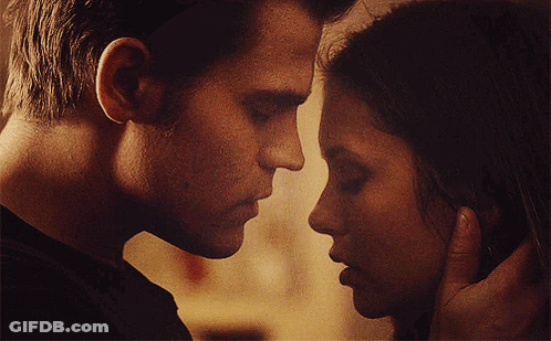 A Man And A Woman Are Touching Their Faces GIF