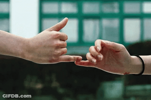 A Man And A Woman Are Touching Their Fingers GIF