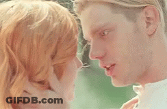 A Man And A Woman Are Touching Their Foreheads And Smiling At Each Other . GIF