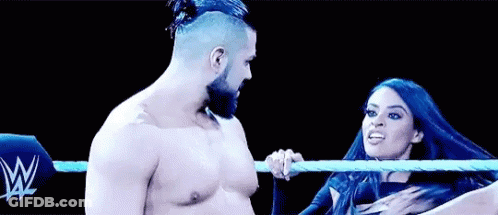 A Man And A Woman Are Wrestling In A Ring . GIF