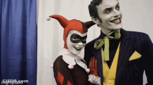 A Man And A Woman Dressed As Harley Quinn And The Joker Pose For A Picture GIF