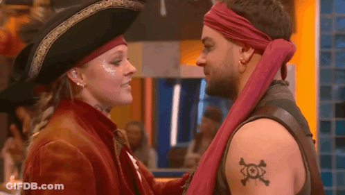 A Man And A Woman Dressed As Pirates Are Looking At Each Other . GIF
