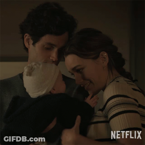A Man And A Woman Holding A Baby With Netflix Written On The Bottom GIF
