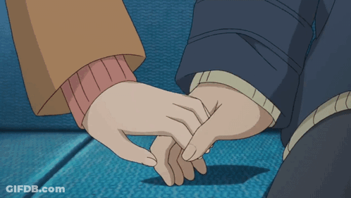 A Man And A Woman Holding Hands On A Blue Couch GIF