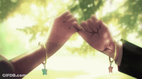 A Man And A Woman Holding Hands With Bracelets On Their Wrists . GIF