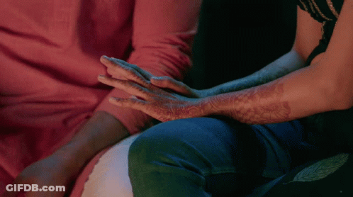A Man And A Woman Holding Hands With Henna On Their Arms GIF