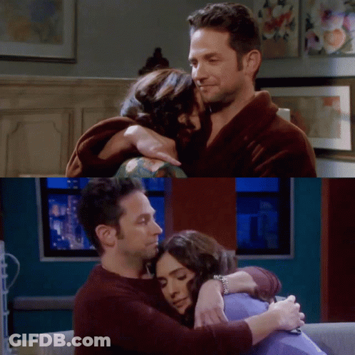 A Man And A Woman Hugging Each Other In A Living Room GIF