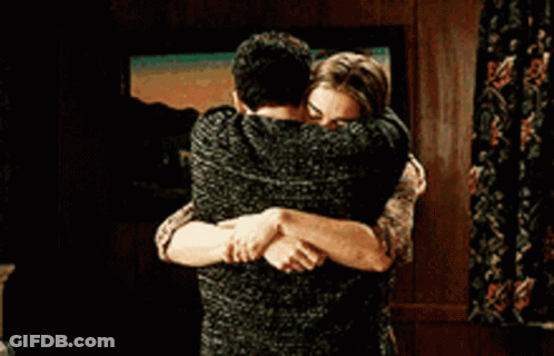 A Man And A Woman Hugging Each Other In A Living Room . GIF