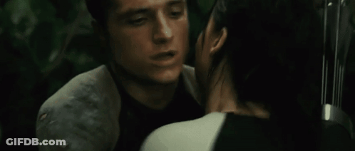 A Man And A Woman Hugging Each Other With A Bow And Arrow In The Background GIF