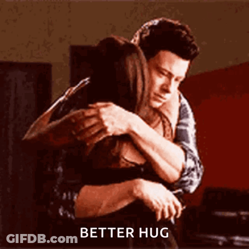A Man And A Woman Hugging Each Other With The Words `` Better Hug '' Written On The Bottom . GIF