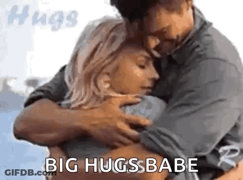A Man And A Woman Hugging Each Other With The Words `` Big Hugs Babe '' . GIF