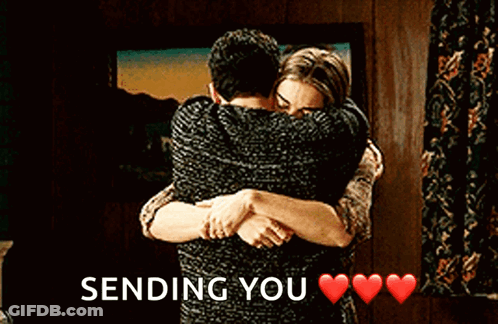 A Man And A Woman Hugging Each Other With The Words `` Sending You '' Written Above Them . GIF