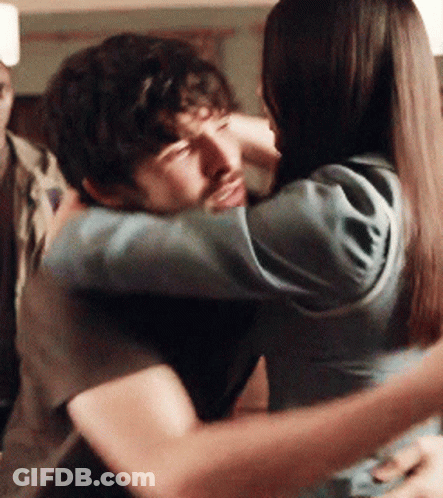 A Man And A Woman Hugging Each Other With Their Eyes Closed GIF