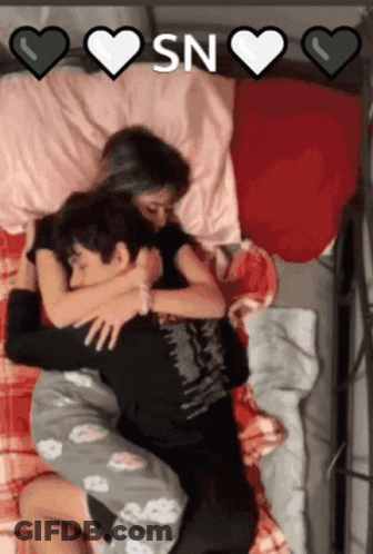 A Man And A Woman Hugging In Bed With The Words " Sn " On The Bottom GIF