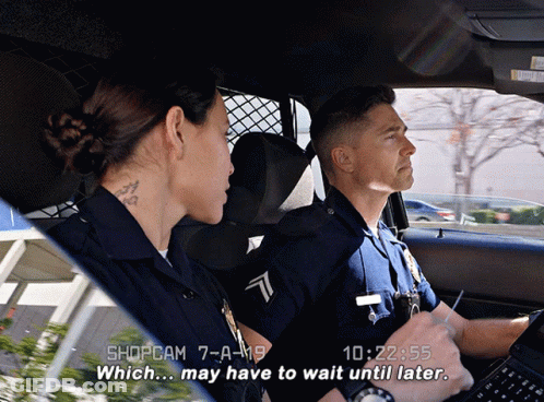 A Man And A Woman In A Police Car With The Time Of 10:22 On The Screen GIF