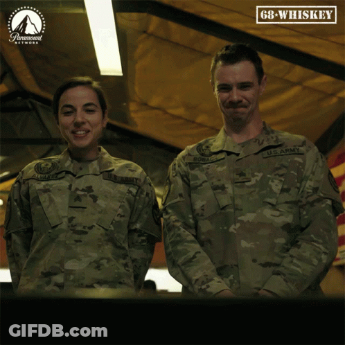 A Man And A Woman In Army Uniforms Are Standing Next To Each Other GIF