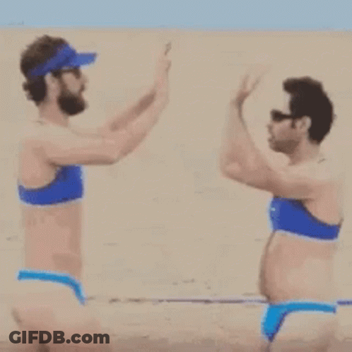 A Man And A Woman In Bikinis Are Walking On A Beach . GIF