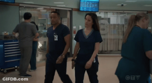 A Man And A Woman In Scrubs Are Walking In A Hospital Hallway With A Ctv Logo In The Background GIF