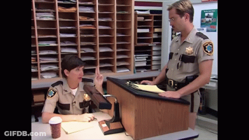 A Man And A Woman In Sheriff 'S Uniforms Talking GIF