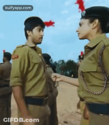 A Man And A Woman In Uniform Are Standing Next To Each Other . GIF